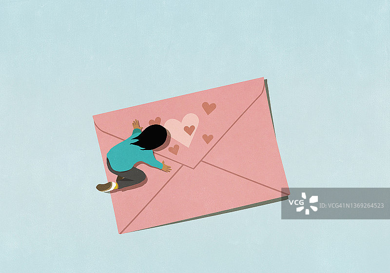 女子跪在粉色心形信封上图片素材