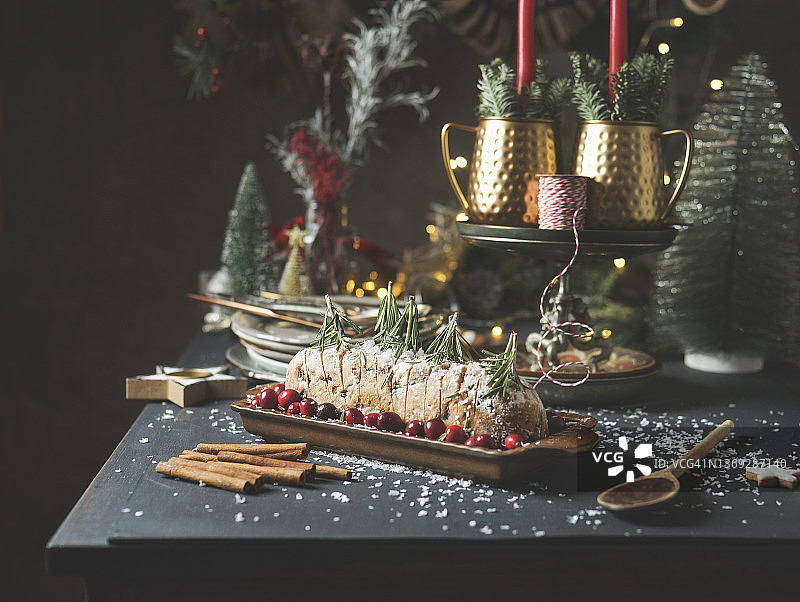 传统德式圣诞蛋糕配蔓越莓、迷迭香和肉桂棒图片素材