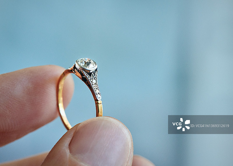 订婚钻戒特写：拇指与食指夹持图片素材
