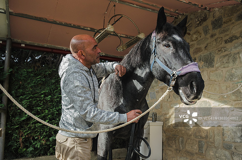 男人在马厩里照顾马图片素材