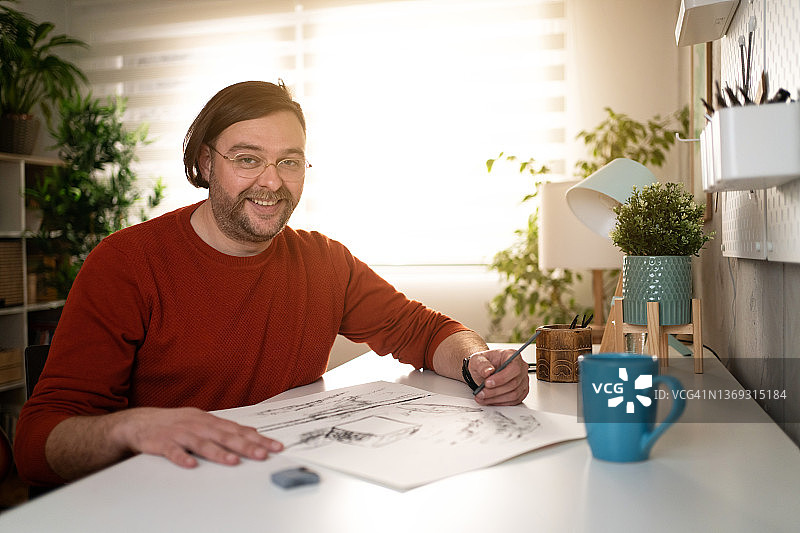 笑容满面的白人男艺术家在家中艺术工作室图片素材