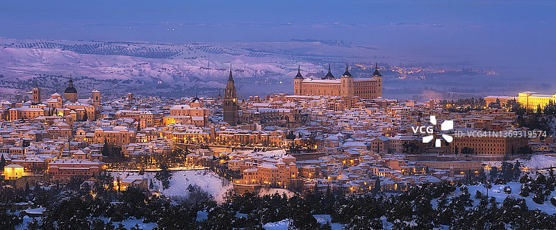 雪山日落时分的城堡老城和灯火通明的街道图片素材
