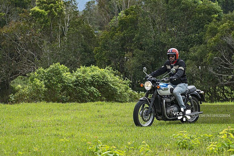 男子在考艾国家公园骑经典摩托车图片素材