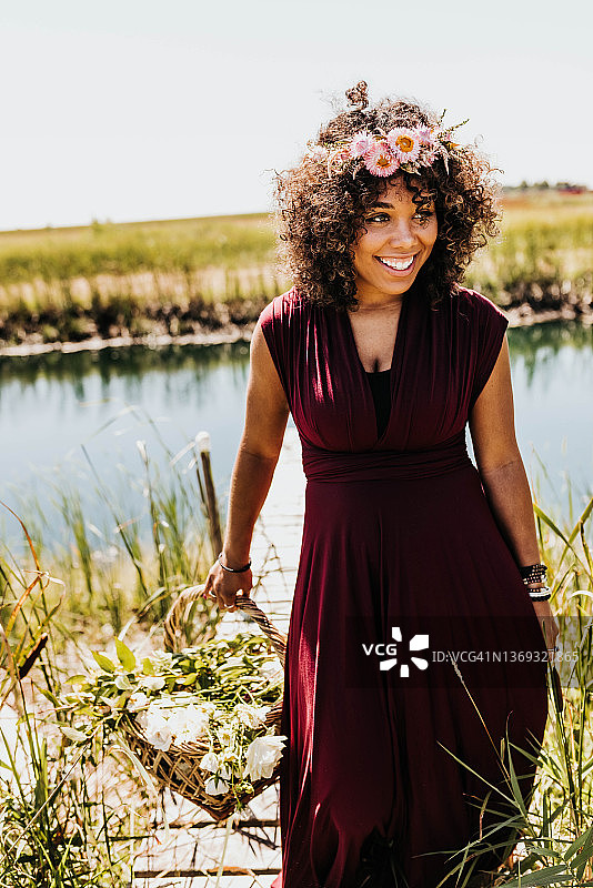 戴着花冠的黑人女子走下池塘附近的码头图片素材