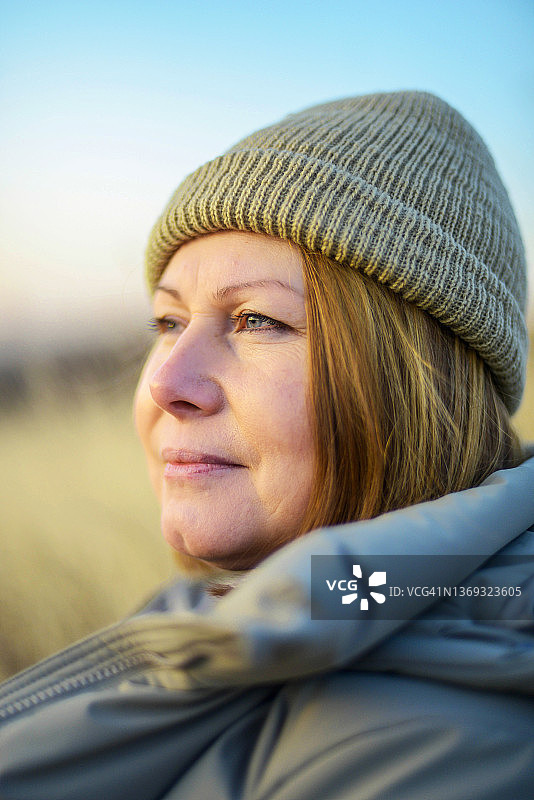 日落时分站在田野里的成年女子肖像图片素材