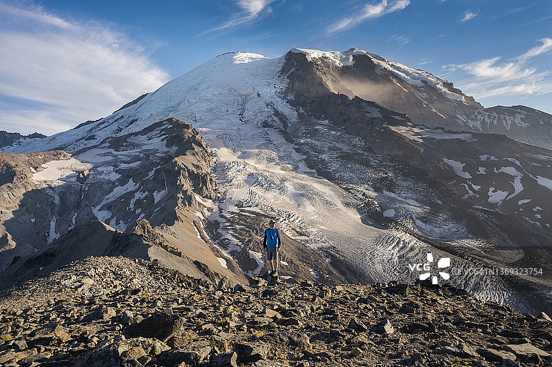 站在雷尼尔山前的持双筒望远镜男人图片素材