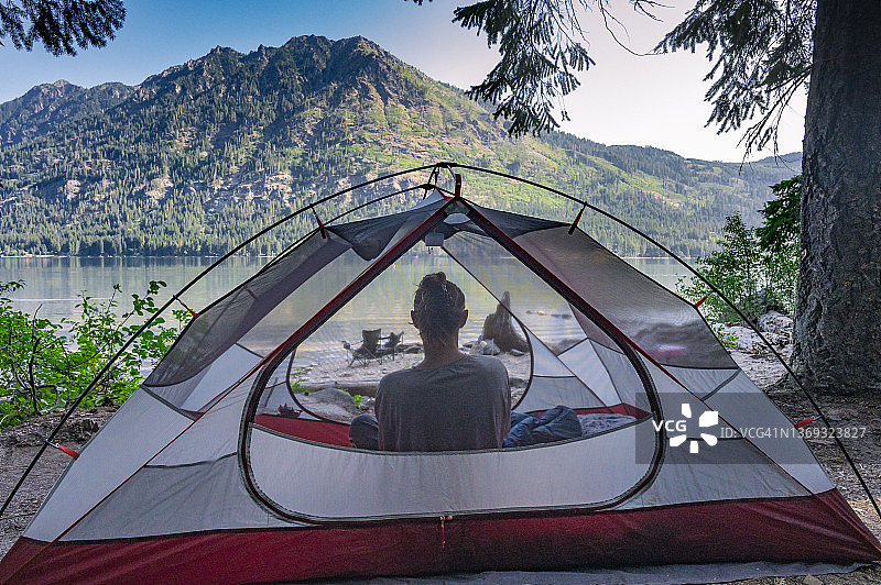人物坐在帐篷里欣赏美丽的山间湖泊图片素材