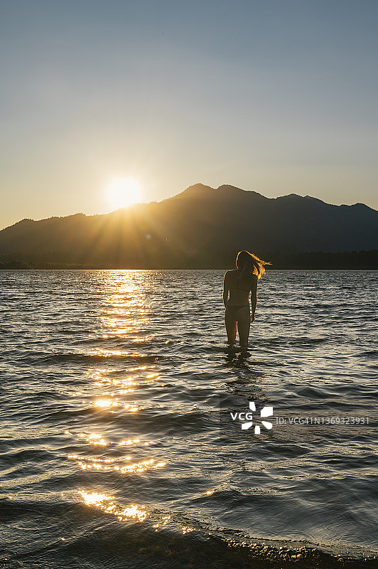 韦纳奇湖日落时分身穿比基尼的游泳女选手图片素材