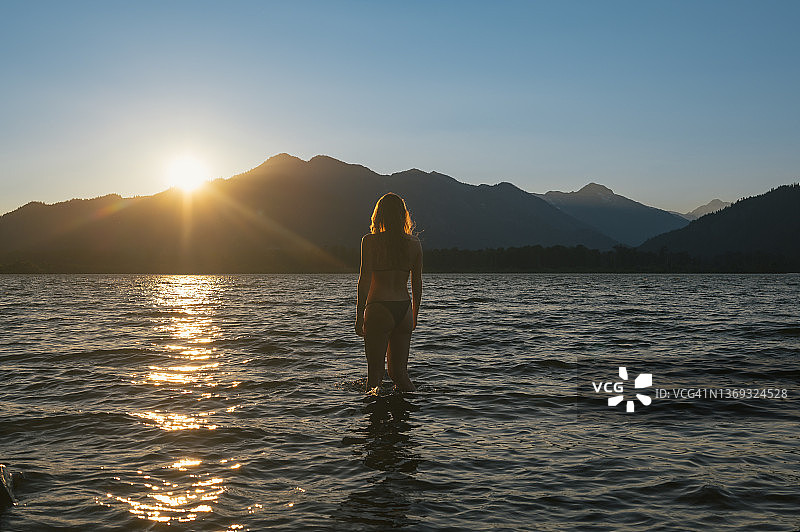 韦纳奇湖日落时分身穿比基尼的游泳女选手图片素材