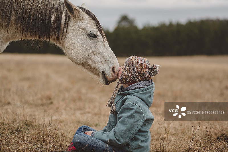 坐在马前亲吻鼻子的少女图片素材