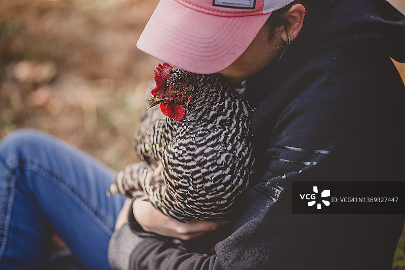 少女抱着小鸡并亲吻它图片素材