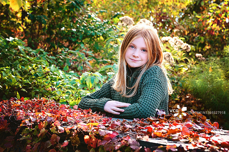 在秋天色彩中快乐的红发少女图片素材