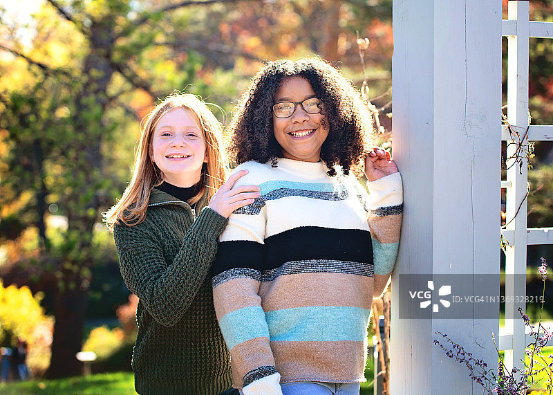 秋色中户外玩耍的两个快乐的少女图片素材