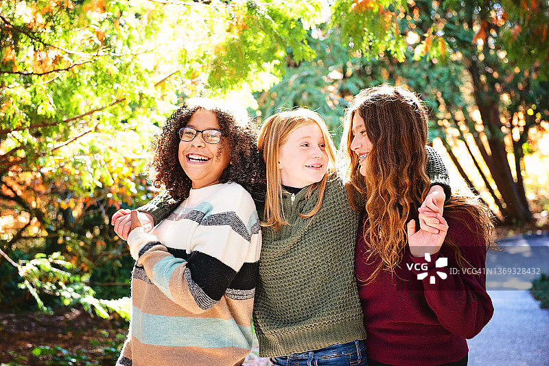三个少女秋日户外欢笑图片素材