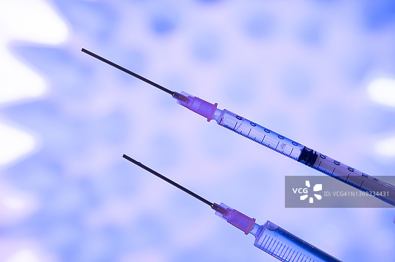 针对奥密克戎或德尔塔等不同新冠病毒突变的两种新冠疫苗注射器，背景是冠状病毒图片素材