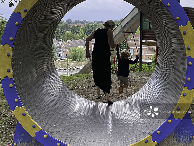 在旋转木马上的幼儿男孩和他的祖母图片素材