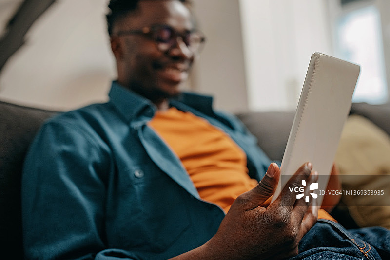 在客厅使用技术的年轻男人图片素材