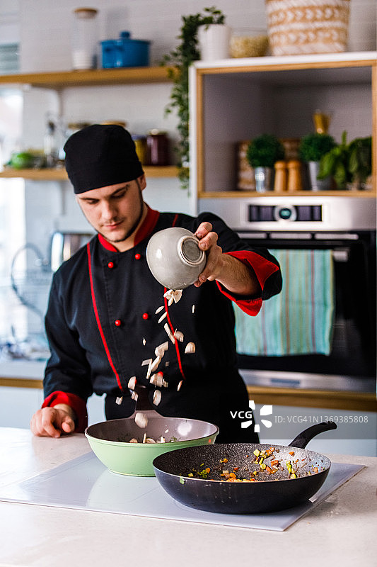 专业厨师将切碎的蘑菇倒入锅中图片素材