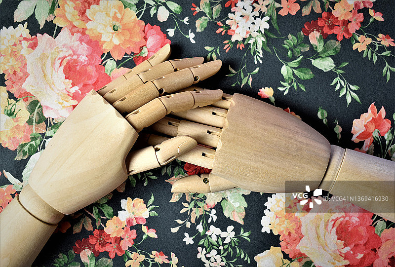 放在鲜花背景上的木制手图片素材