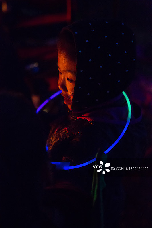 在黑暗中拿着荧光棒的女孩图片素材