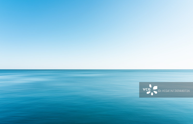 平静的海面融入天空图片素材