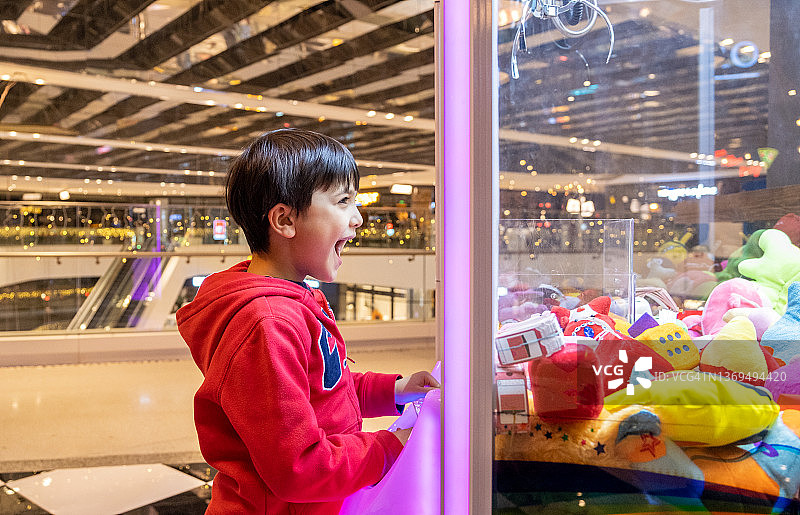 孩子玩抓娃娃机游戏图片素材