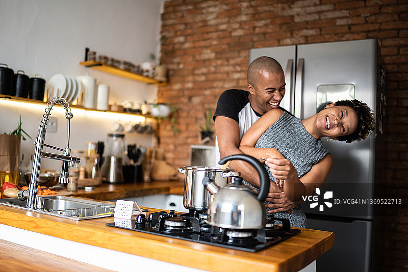 年轻情侣在家拥抱和做饭图片素材