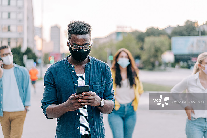 戴防护口罩在城市户外行走的人们图片素材