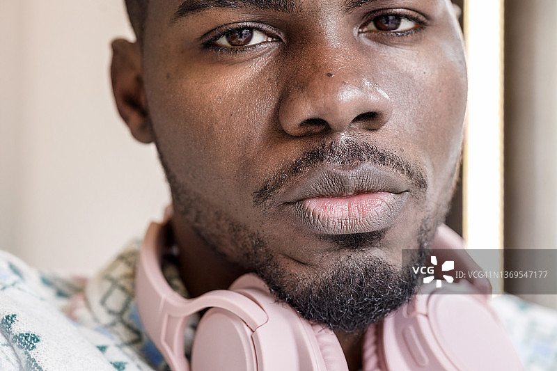 戴着耳机的年轻非裔美国男子的特写图片素材