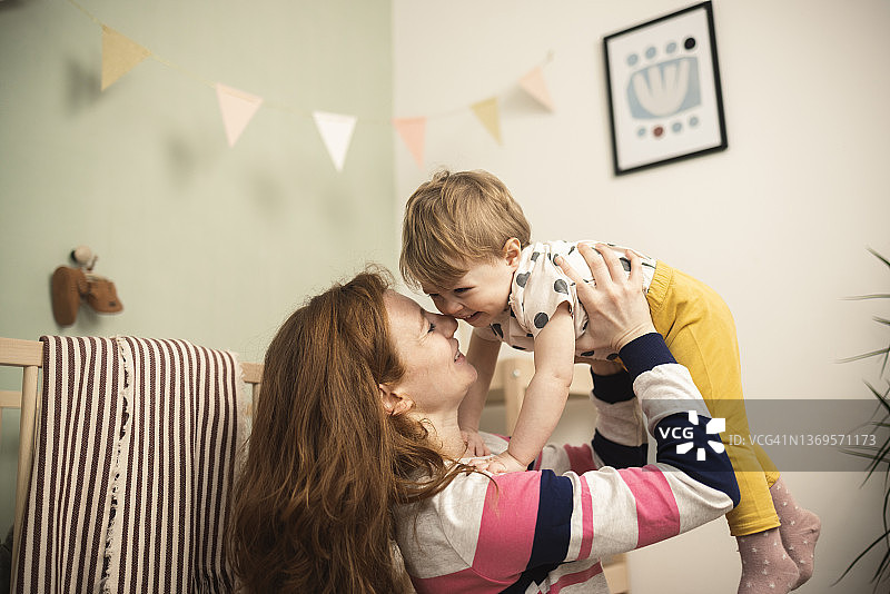 和可爱宝宝一起玩耍的年轻女性肖像图片素材