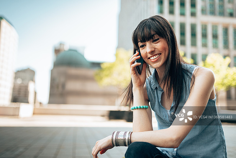 快乐的年轻女人在打电话图片素材