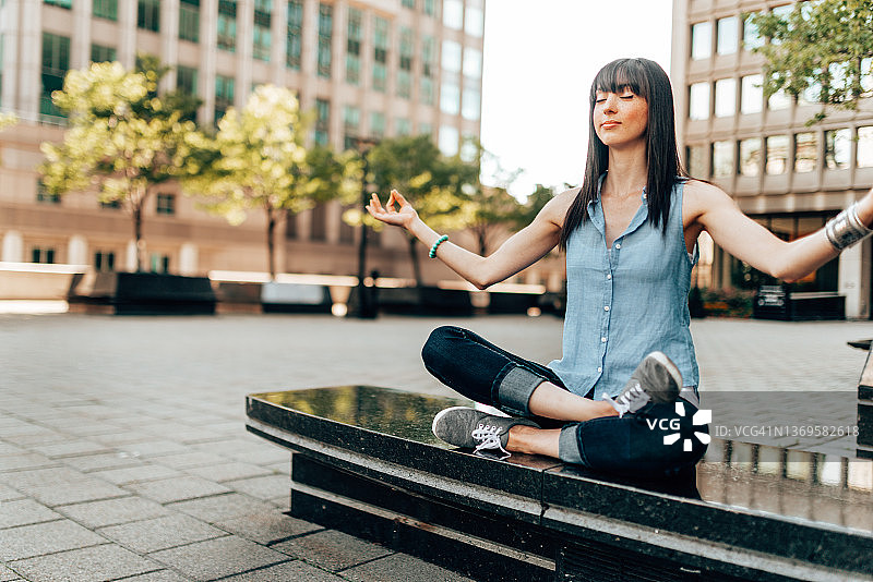 年轻女人在城市里上瑜伽课图片素材