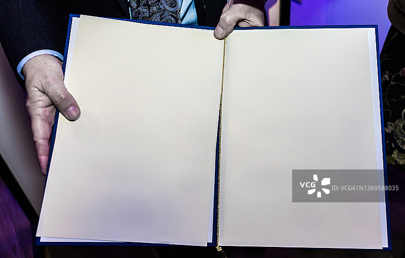 两只手拿着一本空白页的书图片素材