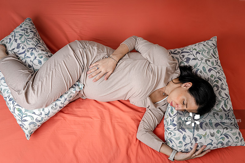 孕妇在床上睡觉，有枕头图片素材