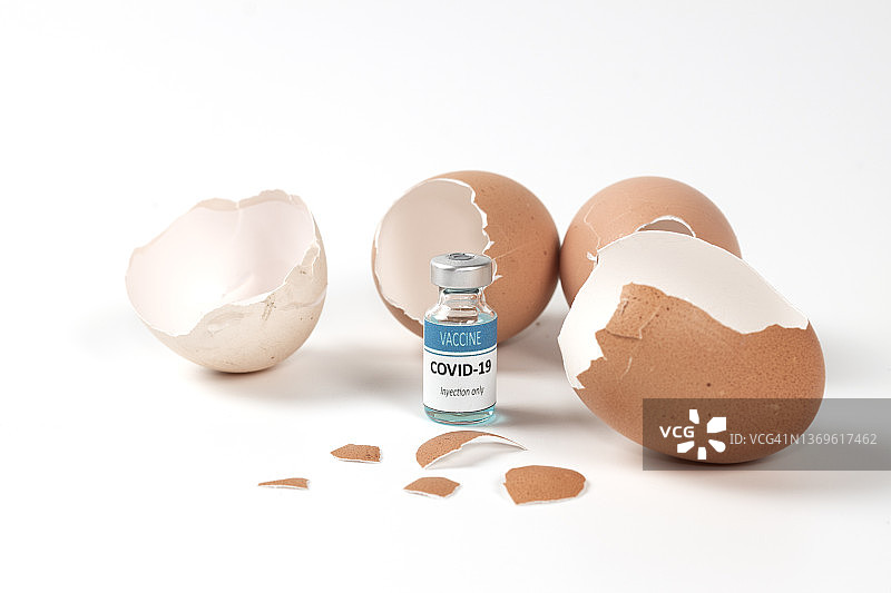 碎鸡蛋壳和新冠疫苗瓶特写（白色背景）图片素材
