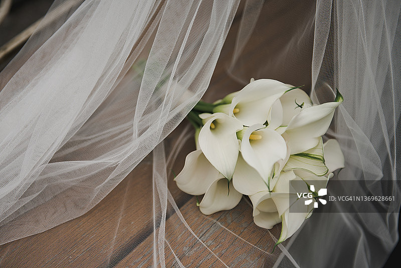白色新娘马蹄莲捧花在面纱上图片素材