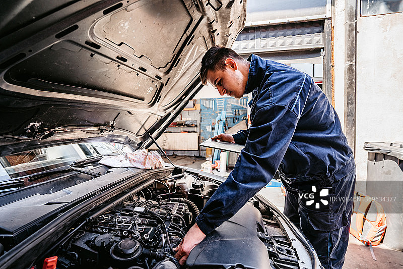 技工在平板电脑上检查汽车诊断图片素材
