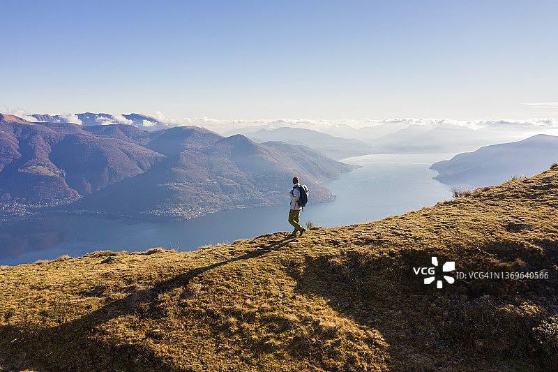 徒步者沿山脊行走，山湖景观航拍图片素材