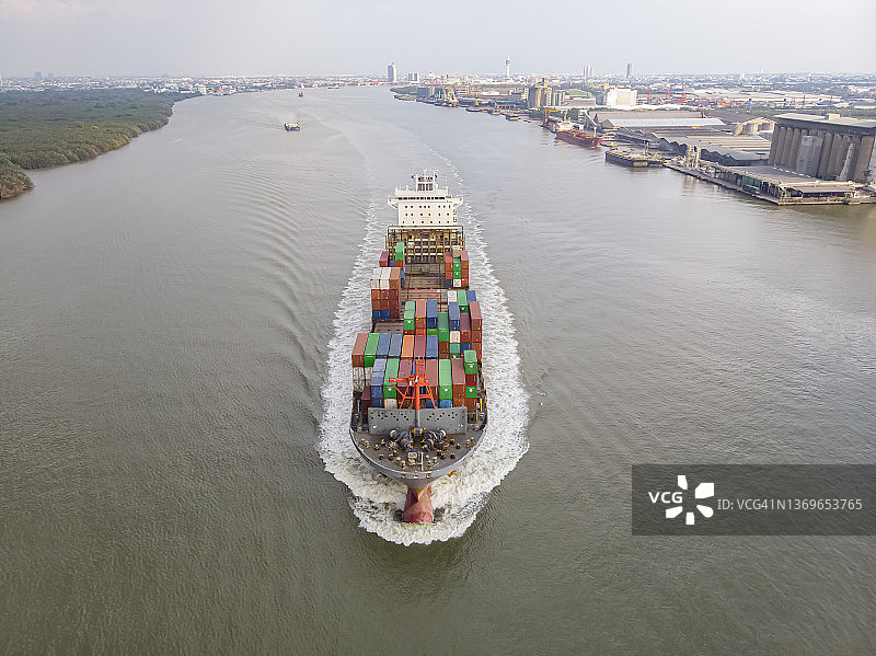 航拍俯视图，由于新冠疫情，装载少量集装箱的集装箱船在河流中航行，用于运输。关于船舶进出口业务。图片素材