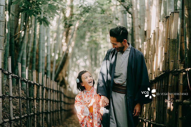 父亲和孩子身穿和服在日本竹林中图片素材