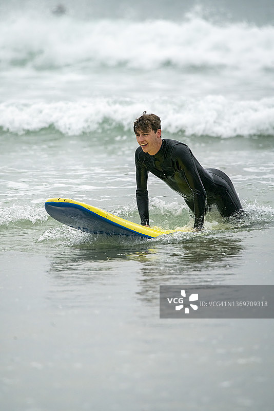 在康沃尔海岸冲浪的年轻男人图片素材