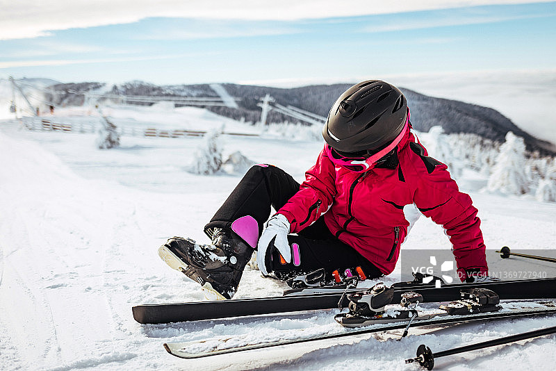 从山坡上摔倒的女子滑雪者图片素材