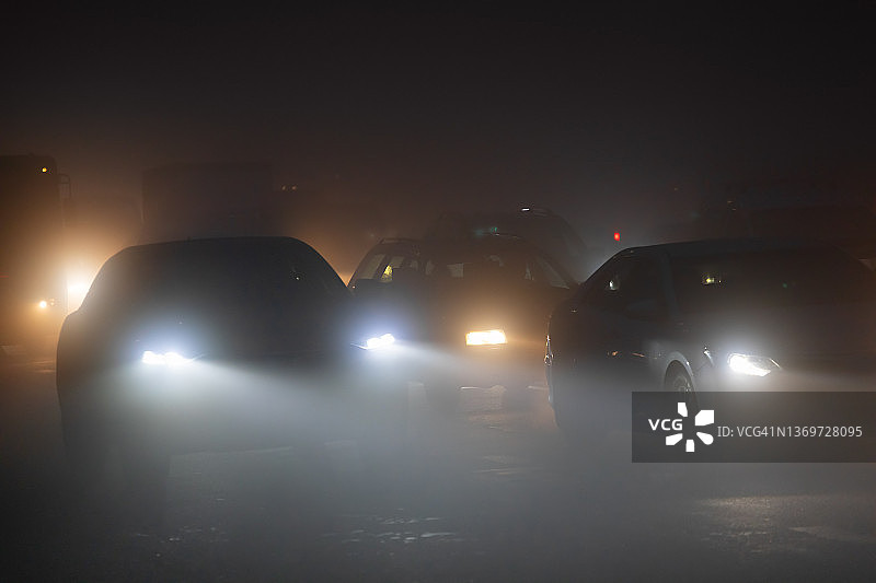夜间雾天城市道路上行驶的汽车图片素材