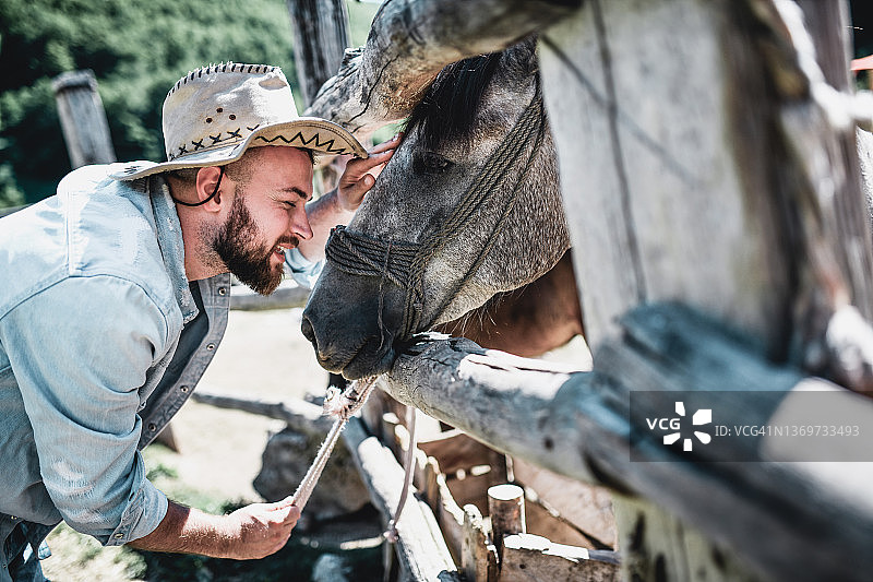 快乐的胡须牧场主和他最喜欢的马在一起图片素材