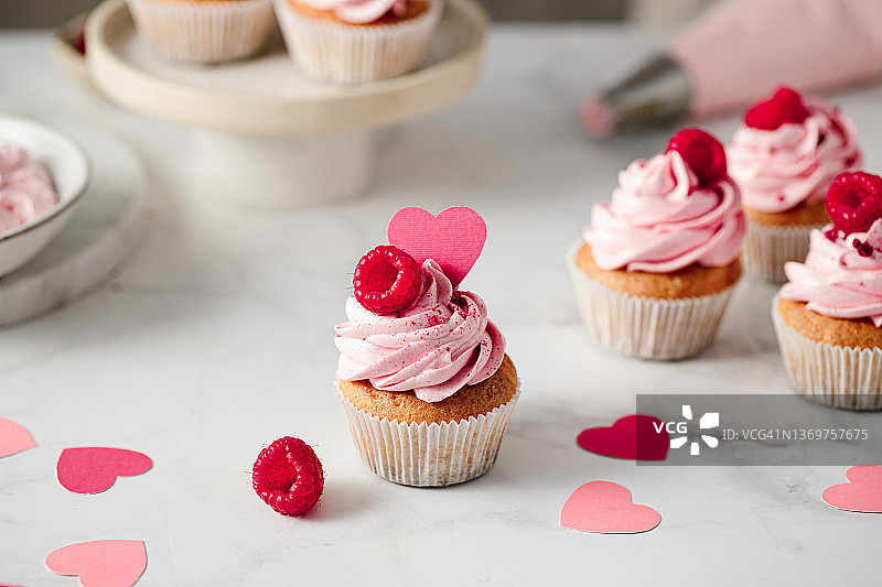 厨房台面上新鲜制作的覆盆子纸杯蛋糕图片素材