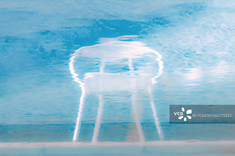 倒映在泳池水中的50年代现代椅子图片素材