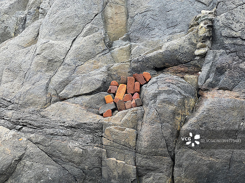 缅因州莫尼根岛上花岗岩巨石中人为放置的砖块图片素材