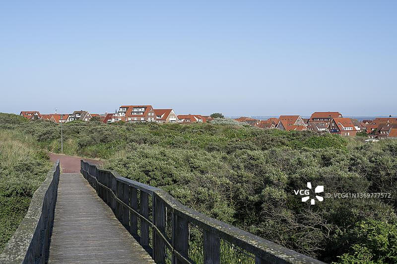 尤斯特岛：通往被植被覆盖的沙丘景观的木板路图片素材