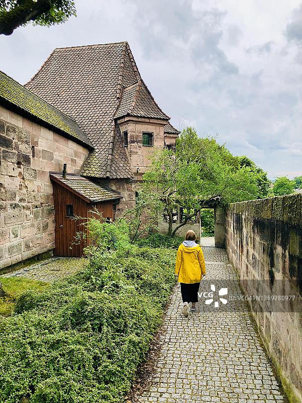 年轻女子漫步于德国巴伐利亚州纽伦堡老城墙图片素材