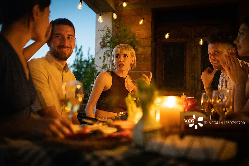 快乐的夫妇在花园里享受晚宴图片素材